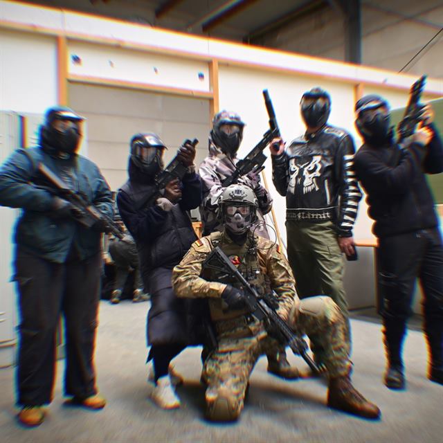Gruppe von Spielern mit Masken und Repliken, OMUNE kniet vorne