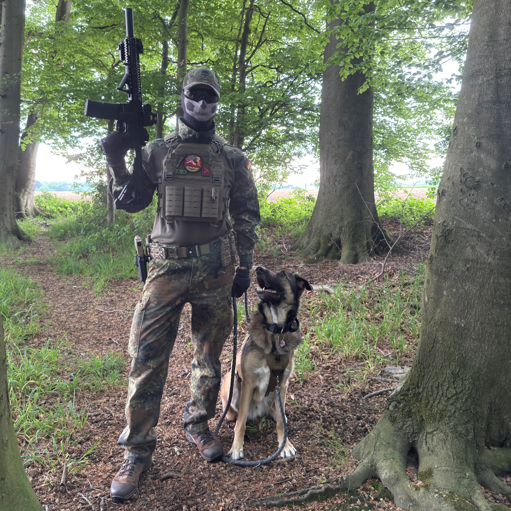 OMUNE in Ausrüstung mit Replik und Schäferhund im Wald (Schwarzweiß)